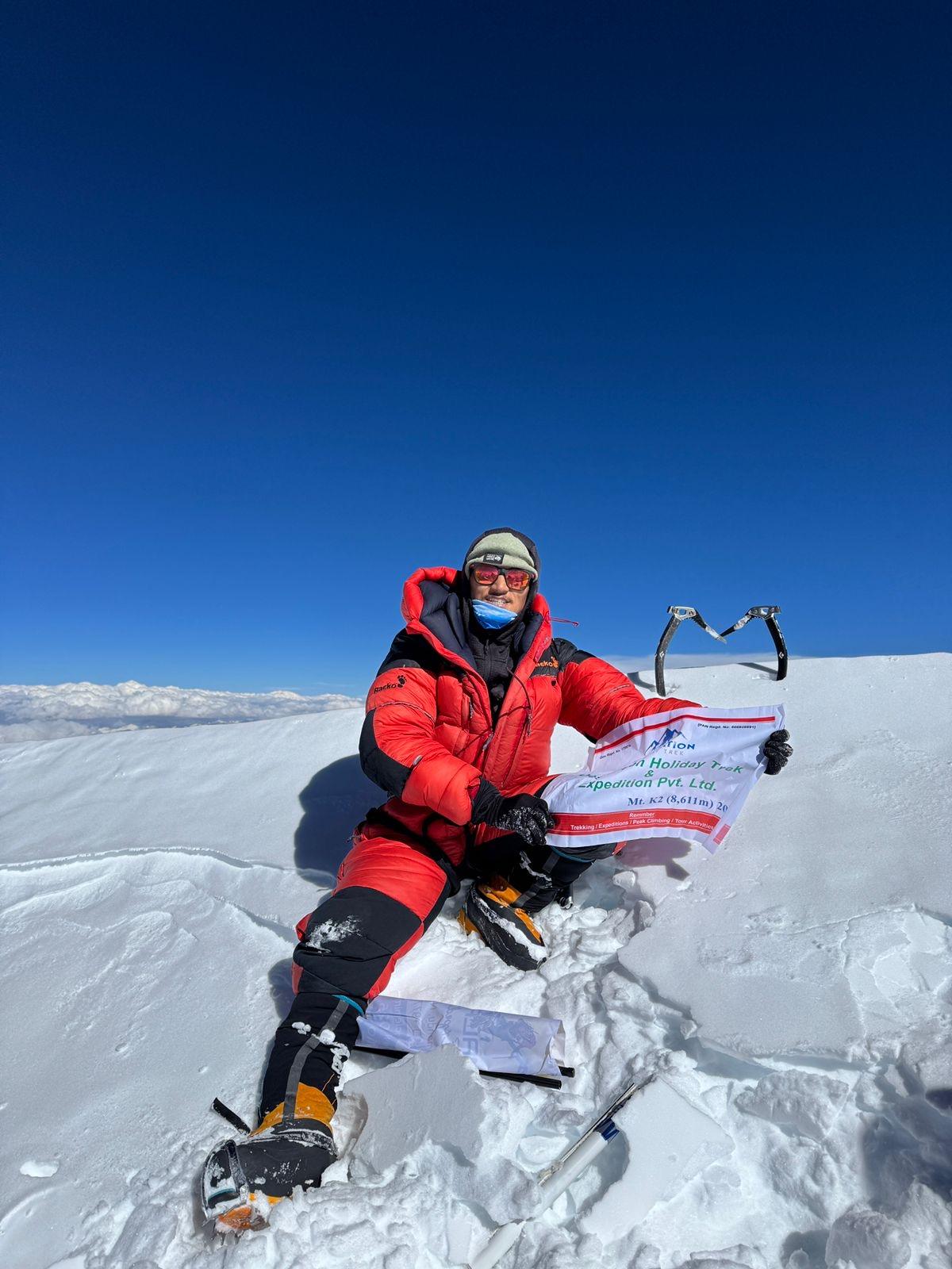 K2 Expedition climber celebrating on summit ridge