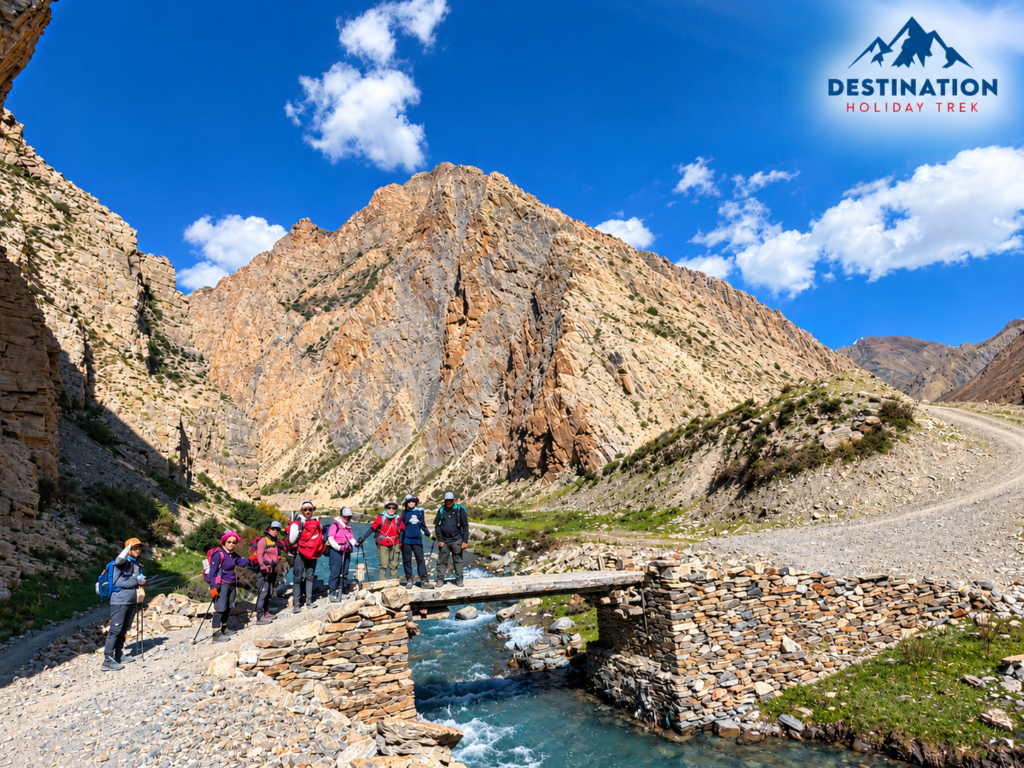 Trekking group posing on a stone and wooden bridge over a river on the Lower Dolpo trek