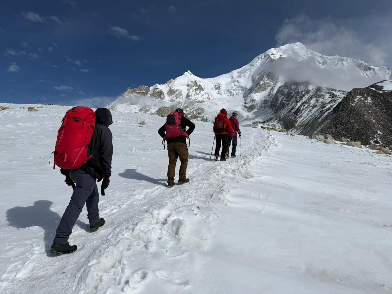 Trekkers crossing a snowy high pass on the Manaslu Circuit Trek